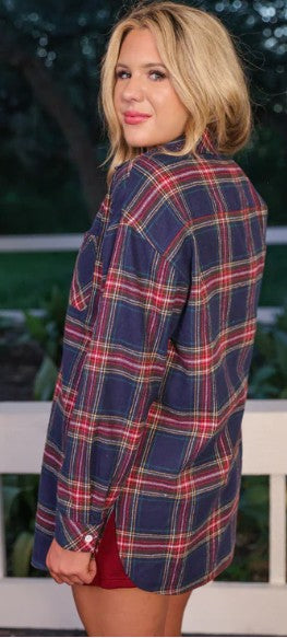 Person wearing a plaid jacket with a blurred outdoor background