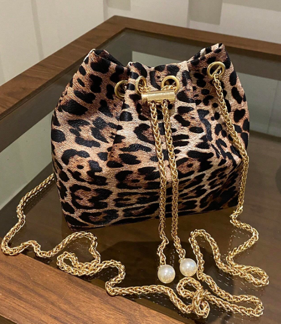 Get ready to brighten up your spring wardrobe with this colorful bucket style shoulder bag! Features include an adjustable strap and handy drawstring closure. This petite bag is fashionable and functional- able to hold your phone, wallet & keys.