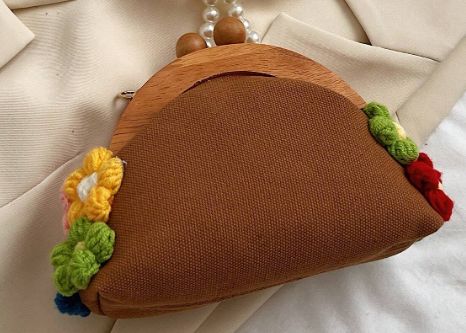 EVERY little girl needs this daintly little purse fit for all the princesses out there! The whimsical design includes yarn flowers in bright colors and a unique pearl string strap, this bag adds a touch of charm to any outfit.