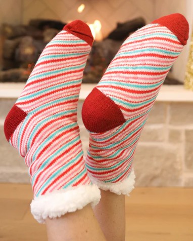 Colorful striped socks with red toes and cuffs worn indoors.