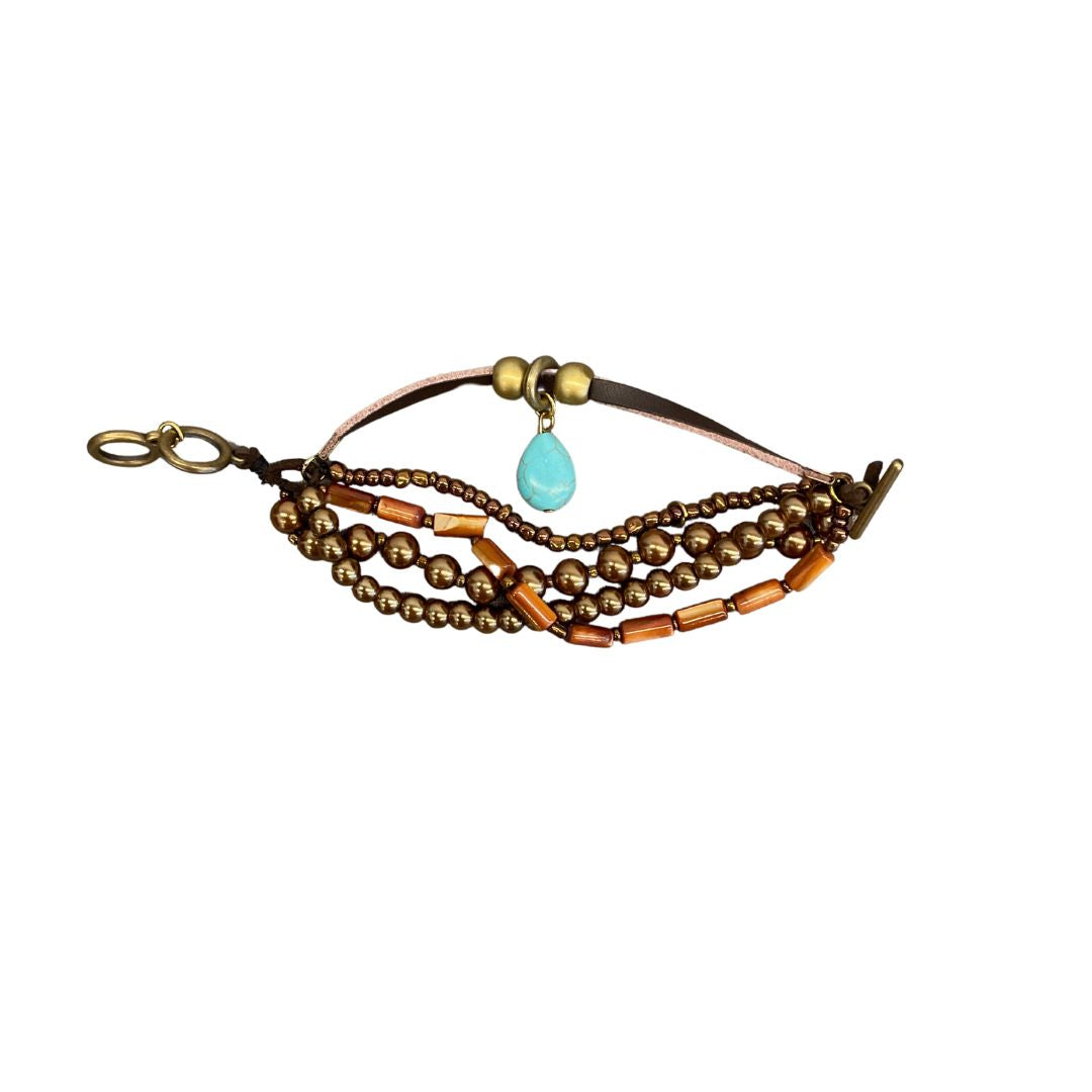 This petite band bracelet attracts interest blending strands of leather, beads & metal finished off with a turquoise teardrop, This is a fun piece to wear!  Measures 7"