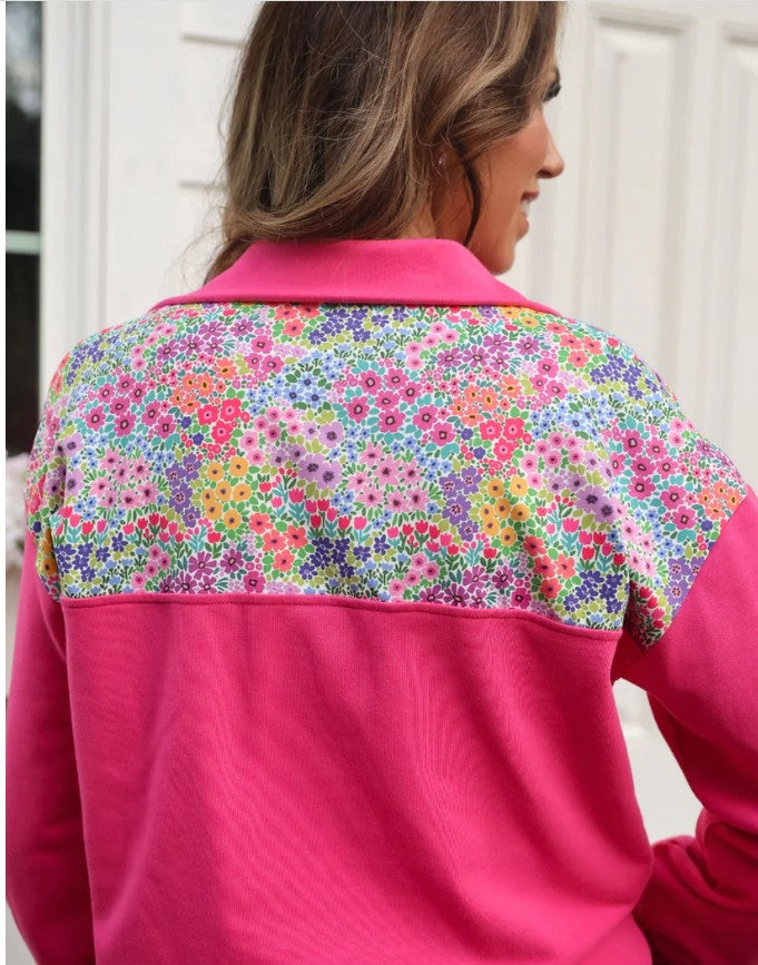 Person wearing a pink jacket with a colorful floral pattern on the back