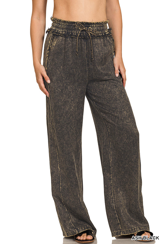Dark denim pants worn by a person on a white background