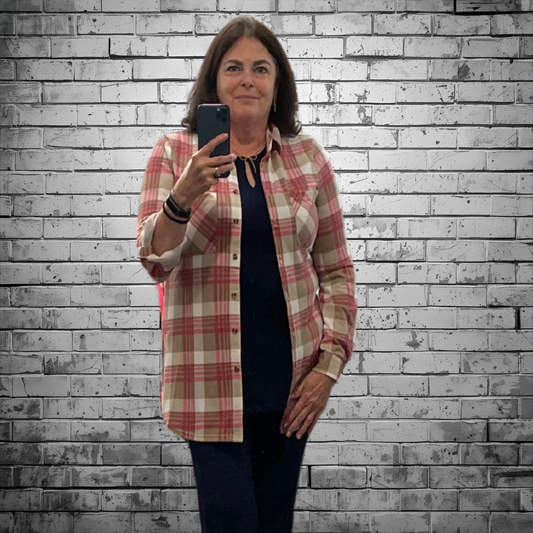 Woman taking a selfie against a textured brick wall