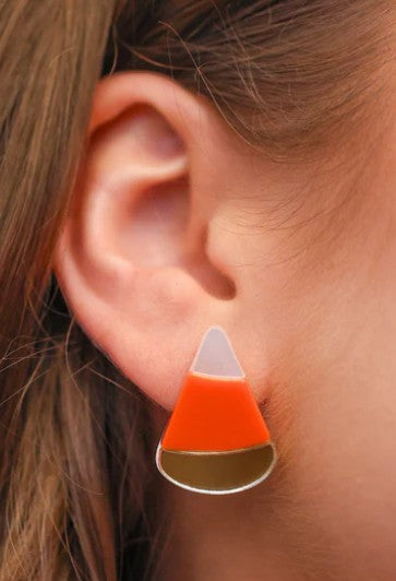 Candy corn-shaped earring worn on an ear