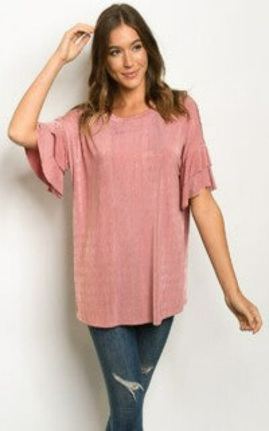 94% polyester / 6% spandex  Shimmer and drape are two reasons to love this slightly longer top- perfect tucked or unticked. The soft blush color and double ruffle sleeves are perfect for any occasion!  Sizing Note: It runs a little big, I wear a Large and Medium fits fine!
